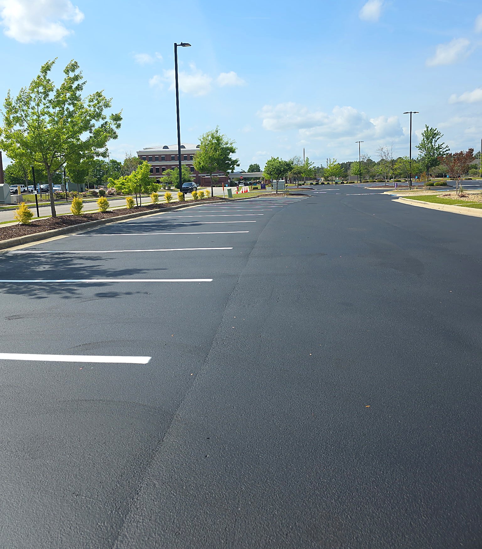 Fresh asphalt drive lane with white parking stalls in Charlotte NC